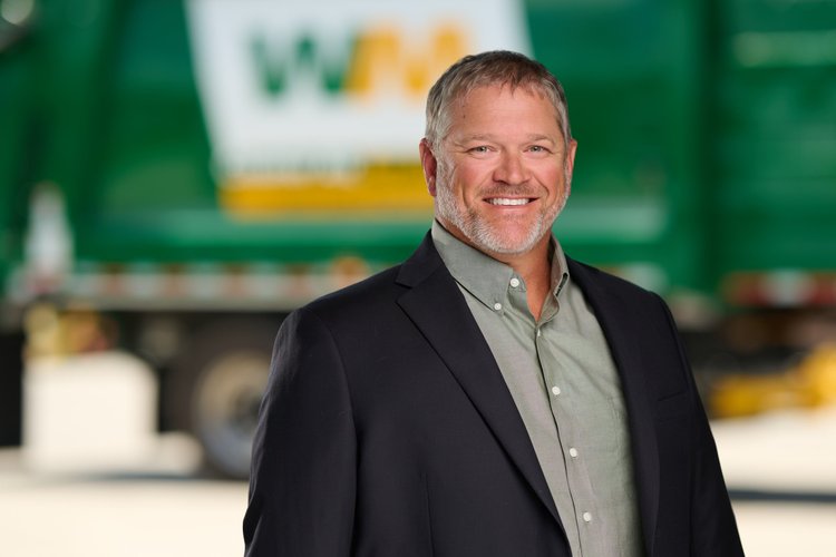 Outdoor professional portrait of a smiling man in a suit.