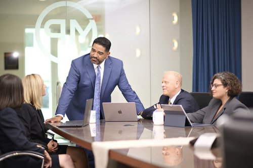 Business team meeting around a conference table with laptops