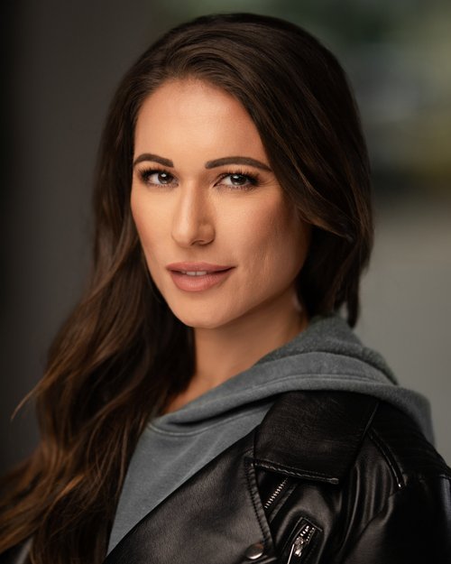 Talent headshot in a black leather jacket with a gray hood