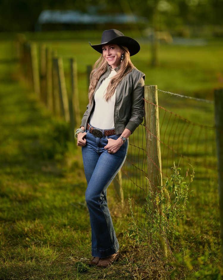 Outdoor portrait of a woman beside a fence at a farm in Bradenton