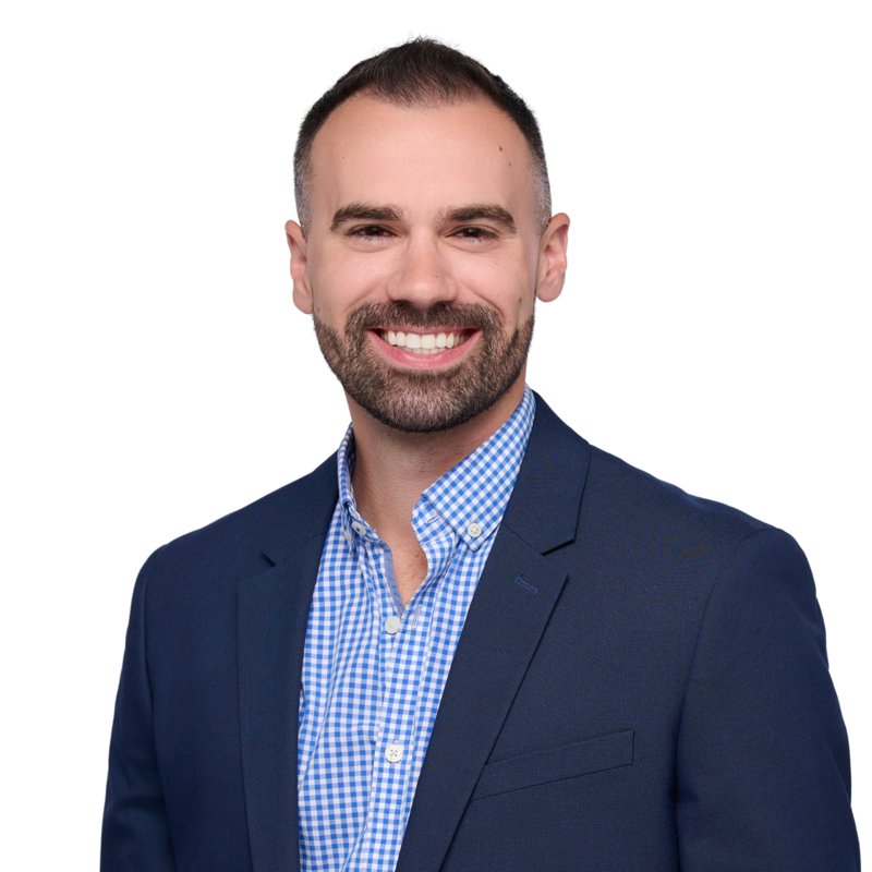 Dees Insurance studio headshot on a white background — navy blazer and blue check shirt