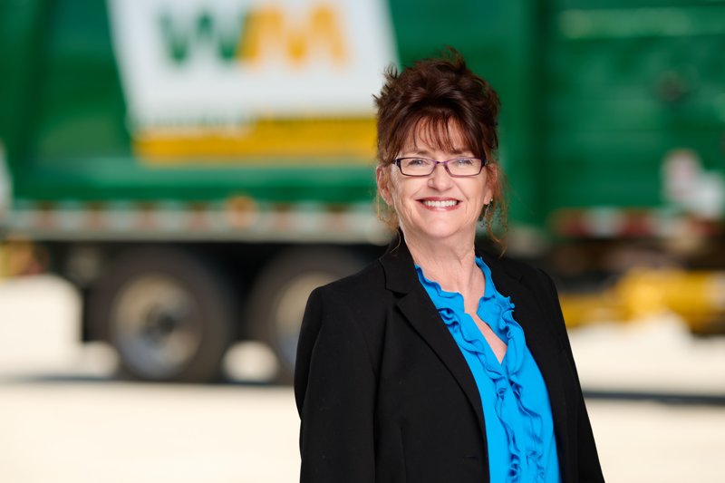 Staff portrait in a black blazer and blue blouse in front of a WM truck