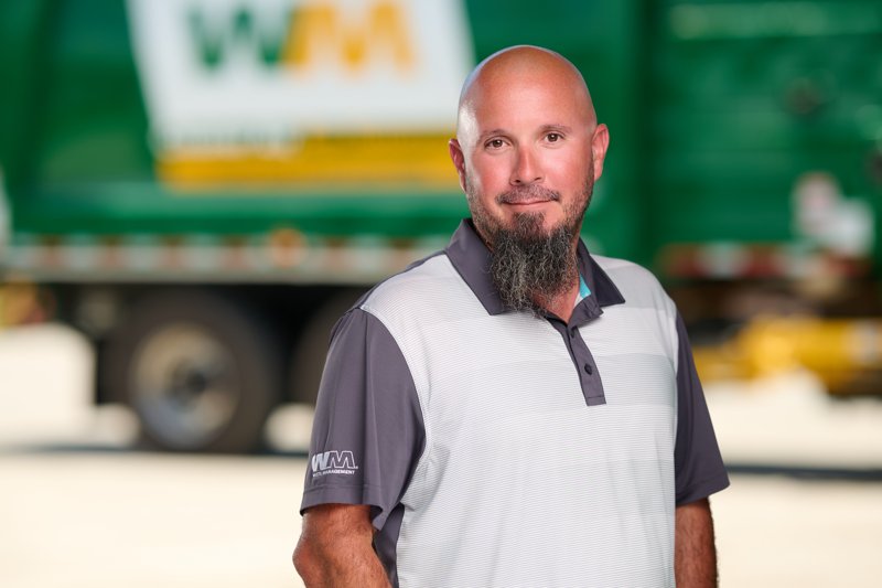Staff portrait in a gray WM polo in front of a company truck
