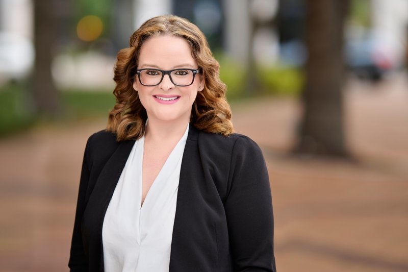 Zarghami Group portrait in downtown Sarasota — glasses, black blazer and white blouse