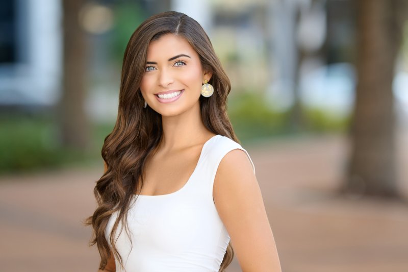 Zarghami Group portrait in downtown Sarasota — white sleeveless top and gold earrings